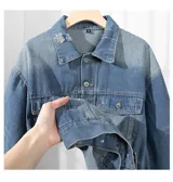 Campera de jean celeste con efecto gastado, corte cuadrado, cuello clásico, cierre con botones metálicos, bolsillos frontales con solapa y bolsillos laterales.