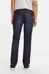 Pantalón de jean de corte slim fit, color azul oscuro, con costuras a la vista en color ocre.