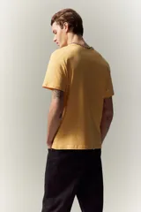 Remera amarilla de algodón liviano, corte estándar, con cuello redondo ribeteado y bajo recto.