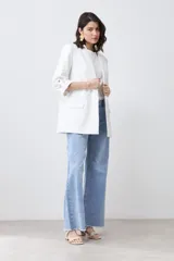 Blazer color crudo de corte recto, con cuello solapa, mangas 3/4 con botón y bolsillos frontales.