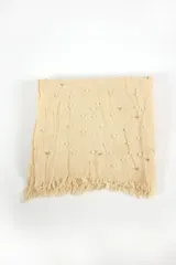 Chalina larga de tejido de punto color negro, con apliques de perlas sintéticas blancas y terminación con flecos.