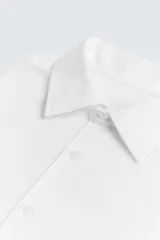 Camisa negra de manga larga con cuello italiano y cierre frontal de botonadura. Presenta un tejido con estructura de fácil cuidado.