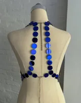 Top tipo corpiño confeccionado con círculos metálicos unidos por pequeñas cadenas, color azul eléctrico. Se ajusta con cadenitas en la espalda y el cuello.