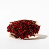 Brazalete rígido dorado con incrustaciones de coral rojo.
