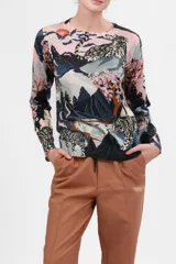 Sweater de cashmere con estampado de leopardos de las nieves en un paisaje montañoso con árboles de cerezo en flor.