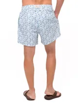 Short de baño celeste con estampado de ballenas en azul y gris. Tiene cintura elástica con cordón ajustable y bolsillos laterales.