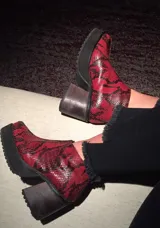 Botas de cuero con estampado de serpiente en rojo, de punta cuadrada y cierre lateral.