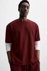 Camiseta negra de corte holgado, con cuello redondo y mangas cortas.