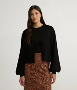 Chaqueta corta de punto color negro, con escote en V, manga larga abullonada, sisa desplazada, abotonado frontal total con botones forrados y puños acanalados.