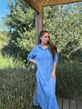 Vestido camisero largo de lino blanco, con corte en la cintura, abertura lateral y botones de nácar.