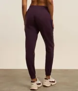 Pantalón deportivo color morado, de algodón y poliéster, con cintura elástica y bolsillos laterales.