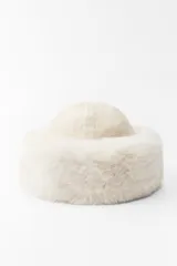 Gorro tipo beanie color crema, confeccionado en tejido de punto con mezcla de lana. Presenta un detalle de vuelta con efecto pelo combinado a tono.