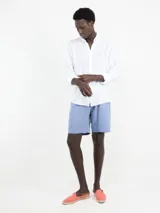 Camisa blanca de lino con corte regular fit, cuello italiano, cierre con botones, manga larga y logo bordado en el pecho.