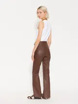 Pantalón de cuero marrón con corte ajustado y aberturas en el ruedo.