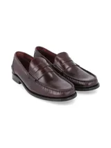 Zapato mocasín de cuero negro con detalle de antifaz y suela plana.