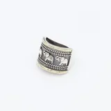 Anillo ancho de plata con detalles en oro, con diseño de elefantes y grecas.