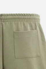 Bermuda negra relaxed fit confeccionada en tejido interlock de algodón con elasticidad. Cintura elástica ajustable con cordón. Bolsillos laterales y detalle de bolsillo trasero de plastrón.