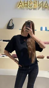 Remera negra de algodón con corte cuadrado, cuello redondo y logo bordado en color naranja.