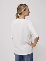 Remera amarilla de algodón con estampado de playa hawaiana con palmeras, flores y tabla de surf.