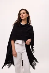 Ruana negra con flecos de algodón.
