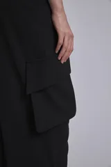 Pantalón cargo negro de corte ancho con bolsillos laterales grandes.