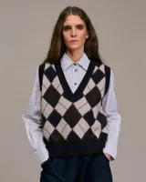 Chaleco de punto con patrón de rombos en tonos beige, marrón y azul marino.