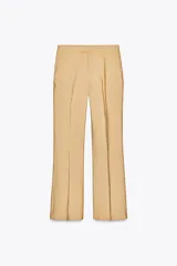 Pantalón de vestir color arena, de tiro medio y corte recto, confeccionado en hilatura con viscosa. Cuenta con bolsillos laterales, raya planchada en delantero y cierre frontal con cremallera, botón y gancho metálico.