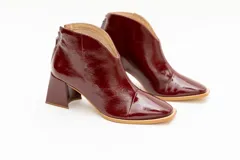 Botinetas plateadas de cuero con punta fina y taco geométrico.