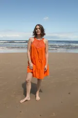 Vestido corto color naranja con escote halter de crochet tejido en hilo de algodón y falda escalonada.