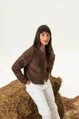 Chaqueta corta marrón de cuero italiano, con cuello redondo, cierre frontal con botones a presión y forro interno.