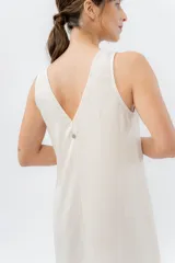 Vestido midi de lino en color verde seco, con escote en V, diseño sin mangas y cierre frontal con botones de madera. Presenta un corte recto y fluido con una abertura frontal en el bajo.