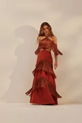 Vestido largo color ladrillo con escote halter, espalda descubierta y falda con tres niveles de flecos.