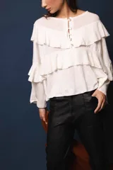 Blusa de lino color blanco, con silueta oversize, cuello bote y volados en el frente.