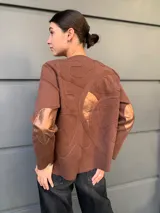 Cárdigan marrón con diseño abstracto en relieve y apliques de cuero en codos y parte superior de la espalda.