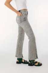 Pantalón de jean azul de corte acampanado con aberturas en el ruedo.