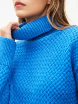 Sweater tejido color verde esmeralda con cuello alto y textura en relieve.