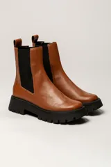 Bota Chelsea color verde militar de cuero, con elásticos laterales negros, tirador trasero y suela track negra.