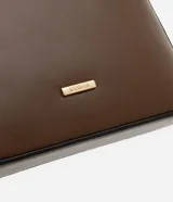 Cartera bandolera pequeña color crema, confeccionada en material sintético con cierre de cremallera y asa larga regulable.