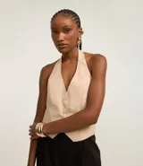 Blusa estilo chaleco color beige, de sastrería, con escote en pico, botones delanteros y espalda ajustable.