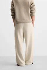 Pantalón largo color beige confeccionado en pana de algodón, de corte wide fit, con bolsillos frontales y traseros.