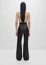 Pantalón de cuero ovino negro, de tiro alto y corte flare. Presenta trabillas, bolsillos laterales y traseros.