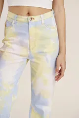 Pantalón de jean de tiro alto con estampado tie-dye en tonos celeste, amarillo y blanco.