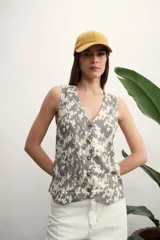 Chaleco con estampado animal print en tonos grises y blancos, con cuello en V y cierre frontal con botones.