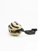 Riñonera color beige con detalles en negro, con tres compartimentos con cierre y correa ajustable con hebilla.