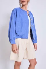 Cazadora color verde oliva con cuello redondo, cierre frontal con botones y mangas largas con puños elásticos.