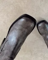 Bota de caña alta color negro, de cuero vegano, con punta cuadrada y taco bloque.