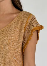 Top tejido color mostaza con escote en V y mangas cortas con detalle de crochet.
