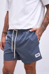 Short de baño azul petróleo con cintura elástica ajustable con cordón.