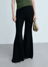 Pantalón de mujer negro, de corte acampanado y tiro alto, con bolsillos laterales y traseros.