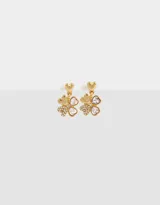 Aros colgantes cortos con dije de trébol bañado en oro, con incrustaciones de strass y dije superior en forma de corazón.